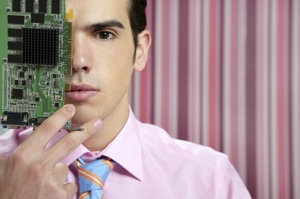 a smartly-dressed young man holding a circuitboard in front of a stripey fashion background