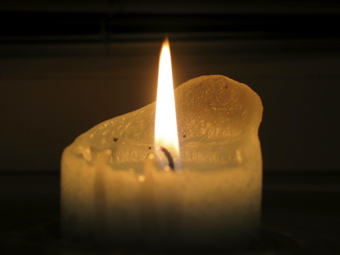 Single candle in dark