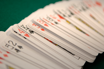 playing cards spread out on green baize