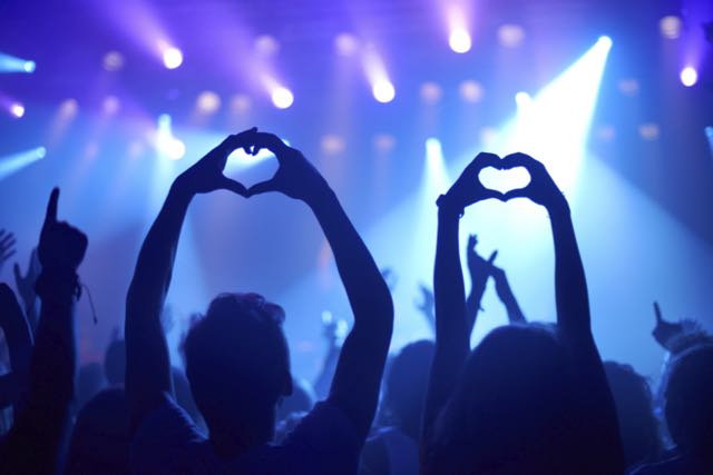 A concert audience with hands as hearts