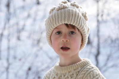 A boy in a woolen hat and jumper in the snow