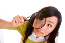a young woman looking through a magnifying glass