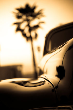 A sepia car leaving the beach