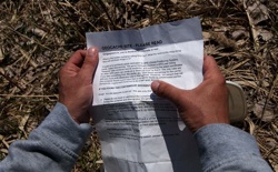 a pair of hands holds a geocaching info sheet
