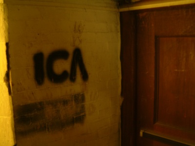 A brick wall with 'ICA' stencilled on it