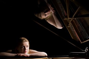 Girl reflecting at a piano with a reflection