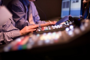 people adjust dials in a control room