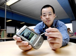 Jeff Yan holding a PDA with a doodle on the screen