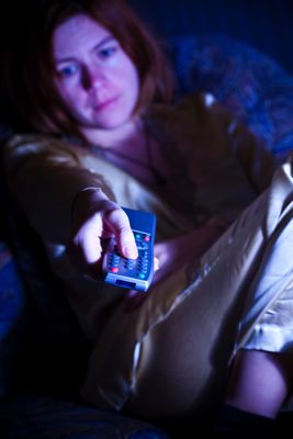 A bored woman with a remote control